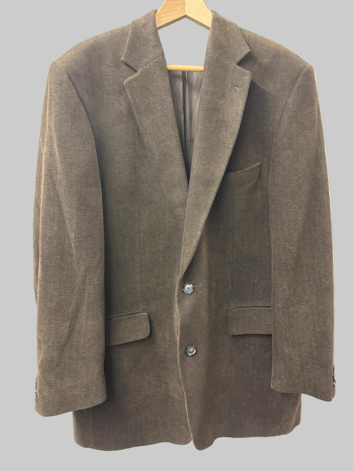 Brown blazer on a hanger against a white background