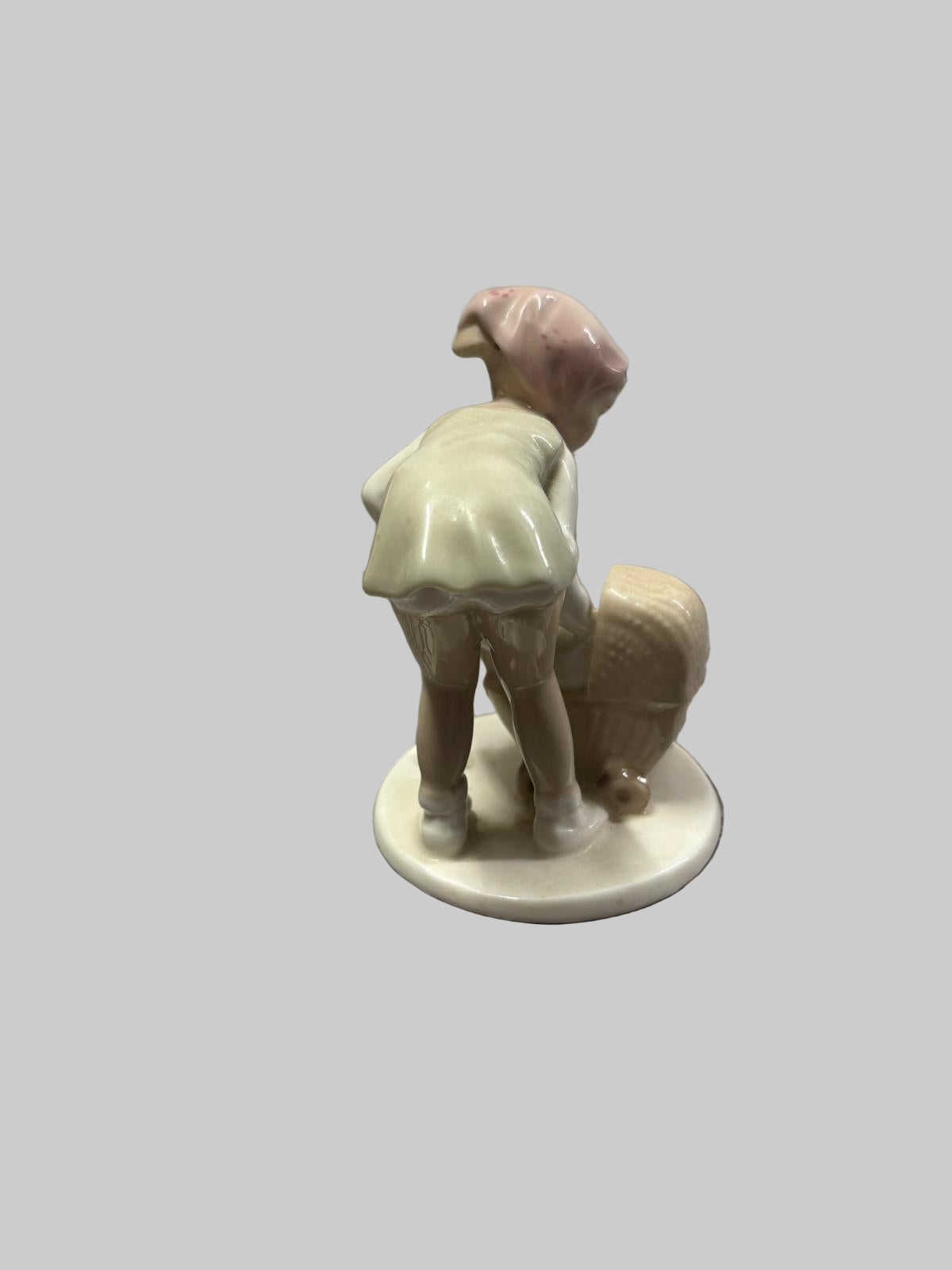 Small figurine of a child with a suitcase on a tiled floor